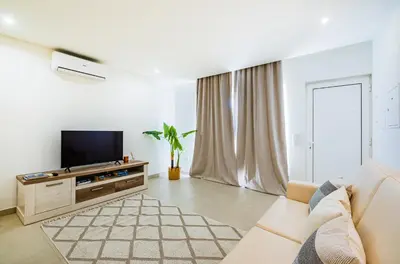 a living room with a couch and a tv at Apartamento oceano in Albufeira