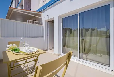 a dining room with a table and chairs and a large window at Apartamento oceano in Albufeira