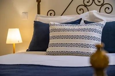 a bedroom with a bed with blue and white pillows at Apartamento oceano in Albufeira