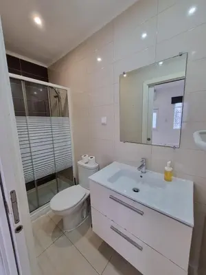 a bathroom with a toilet and a sink and a mirror at By the Sea Apartments B3 in Albufeira