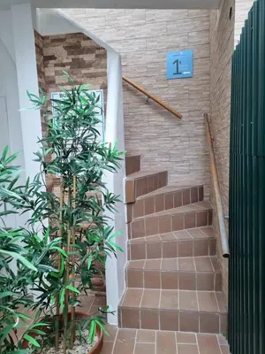 a stairway with a brick wall and stairs with a plant at By the Sea Apartments B3 in Albufeira
