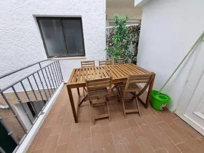 a wooden table and chairs on a balcony at By the Sea Apartments B3 in Albufeira