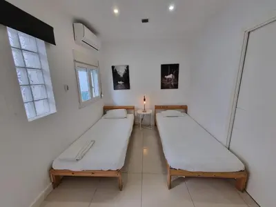 two beds in a room with two windows at By the Sea Apartments B3 in Albufeira