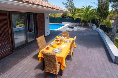 a table and chairs on a patio next to a pool at Balaia Retreat - Nature & Beach in Olhos de Água