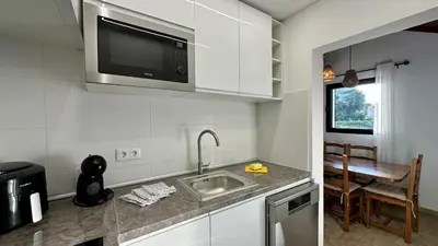a kitchen with a sink and a microwave at Gemini by Check-in Portugal in Albufeira