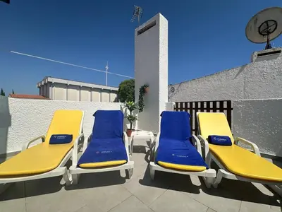two blue and yellow lounge chairs on a roof at White House By FHR in Quarteira