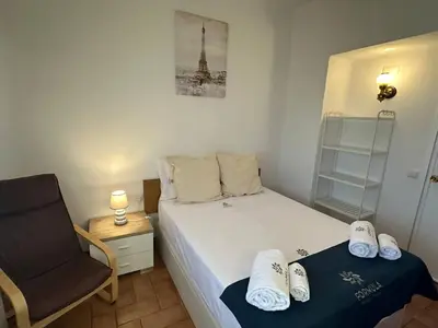 a small bedroom with a bed and a chair at White House By FHR in Quarteira