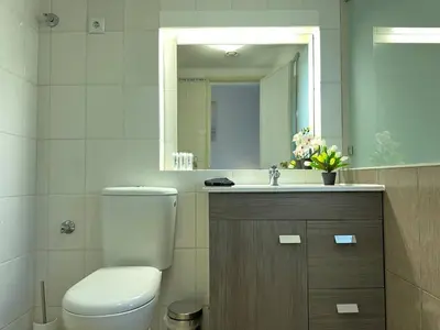 a bathroom with a toilet and a sink and a mirror at White House By FHR in Quarteira