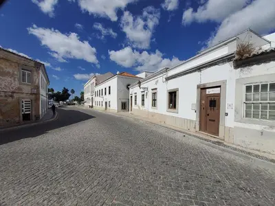 an empty street with white buildings and a blue sky at Blife Castelya private property in Faro