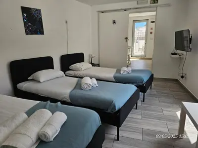 a room with three beds and a flat screen tv at Blife Castelya private property in Faro