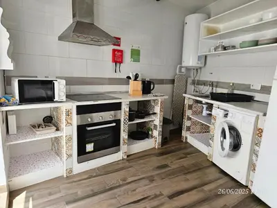 a kitchen with white cabinets and a stove top oven at Blife Castelya private property in Faro