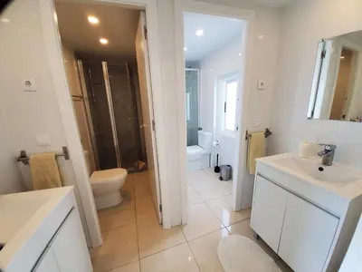 a white bathroom with a toilet and a sink at Blife Castelya private property in Faro
