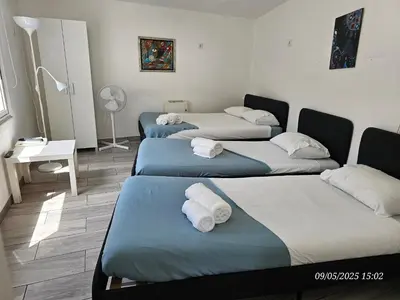 a room with three beds with towels on them at Blife Castelya private property in Faro