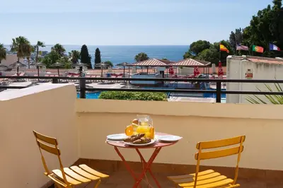 a table with a plate of food on top of a balcony at NEW! Dream Terrace Albufeira Ocean and Pool Views in Bicas