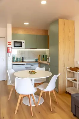 a kitchen with a white table and white chairs at NEW! Dream Terrace Albufeira Ocean and Pool Views in Bicas