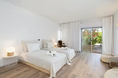 a white bedroom with two beds and a window at Bmyguest - Vale do Lobo Family Beach Villa in Vale do Lobo