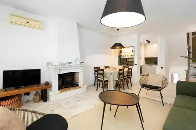 a living room with a fireplace and a dining room at Bmyguest - Vale do Lobo Family Beach Villa in Vale do Lobo