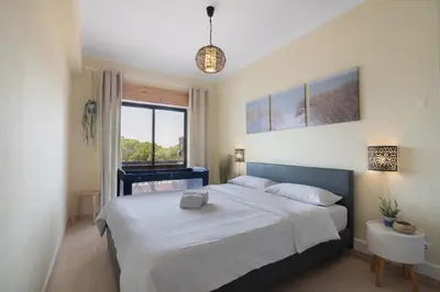 a bedroom with a large bed and a window at Marbel Sol Apartment Al in Quarteira