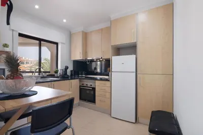a kitchen with a table with a bowl of pineapple on it at Marbel Sol Apartment Al in Quarteira