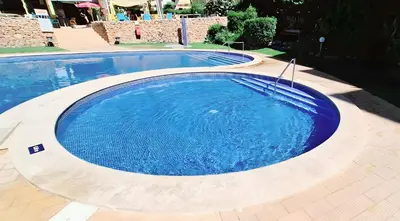 a large blue swimming pool in a yard at Marbel Sol Apartment Al in Quarteira
