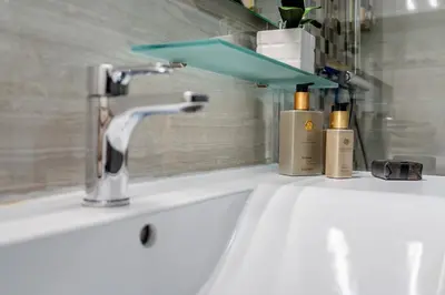 a bathroom sink with a faucet and two bottles on it at Prestige Flat by Albufeira Holidays in Albufeira