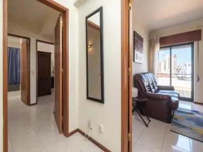 a living room with a couch and a mirror at Faro Charm Apartment - City Center in Faro
