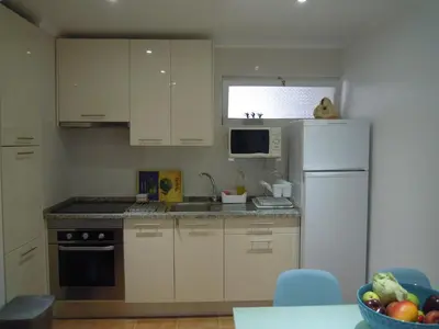 a kitchen with white cabinets and a white refrigerator at Charming House in Albufeira with Shared Pool in Albufeira