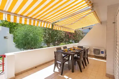 a dining room with a table and chairs on a balcony at HostWise - Sunny Escape with a Pool & Balcony in Vilamoura