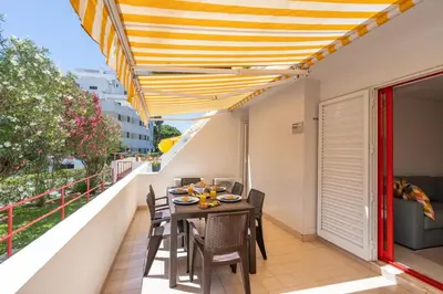 a balcony with a table and chairs on it at HostWise - Sunny Escape with a Pool & Balcony in Vilamoura