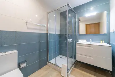 a bathroom with a glass shower and a sink at Golden View Villa by HelloVacations in Albufeira