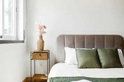 a bedroom with a bed with a vase on a table at Sea Side in Albufeira