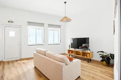 a living room with a white couch and a tv at Sea Side in Albufeira