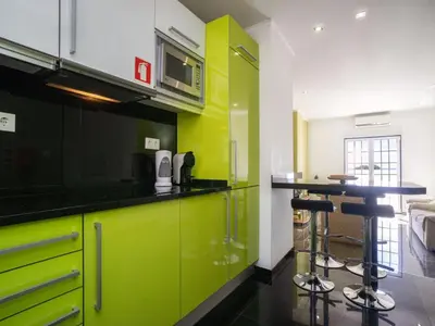 a kitchen with lime green cabinets and a bar at Akivillas Albufeira Repose in Albufeira
