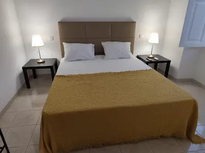 a bedroom with a large bed with two night stands at Simply House in Faro