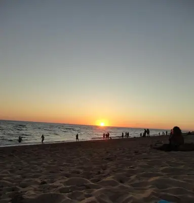a group of people on the beach at sunset at Simply House in Faro