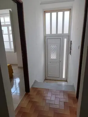an empty hallway with a door and a wooden floor at Simply House in Faro