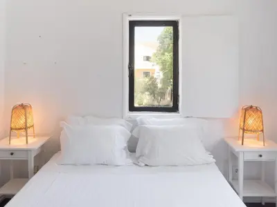 a white bed with white pillows and a window at Delta Marina in Vilamoura