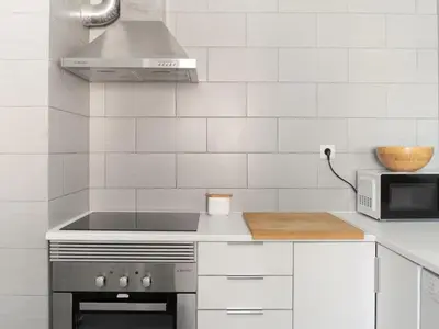 a white kitchen with a stove and a microwave at Delta Marina in Vilamoura