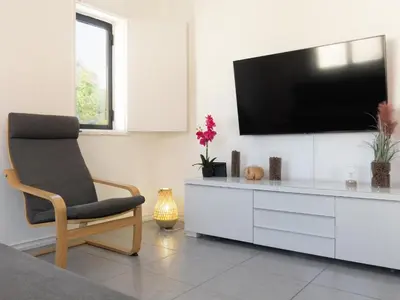 a living room with a tv and a chair at Delta Marina in Vilamoura