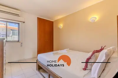 a bedroom with a bed with a home holidays sign on it at #295 Beco do Sol 29A by Home Holidays in Albufeira