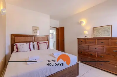 a bedroom with a large bed and a dresser at #295 Beco do Sol 29A by Home Holidays in Albufeira
