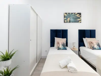 a bedroom with two beds and a mirror at Akisol Faro Cobalt in Faro