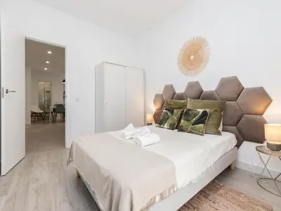 a white bedroom with a large bed and a mirror at Akisol Faro Cobalt in Faro