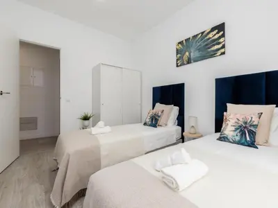 two beds in a room with white walls at Akisol Faro Cobalt in Faro