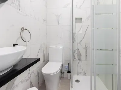 a bathroom with a toilet and a sink and a shower at Akisol Faro Cobalt in Faro
