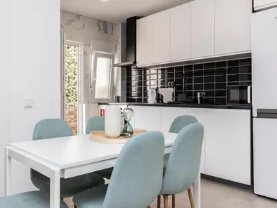 a kitchen with a white table and blue chairs at Akisol Faro Cobalt in Faro
