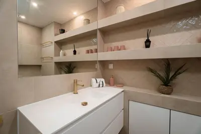 a bathroom with a white sink and shelves at Vilamoura Collection in Quarteira
