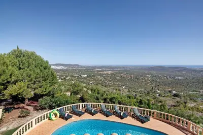 a view of a swimming pool with chairs and trees at Quinta da Violeta in Loulé