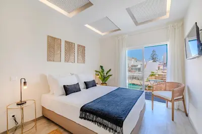 a bedroom with a bed and a large window at The 23 Suites in Faro