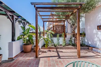 a pergola on a patio with plants at The 23 Suites in Faro